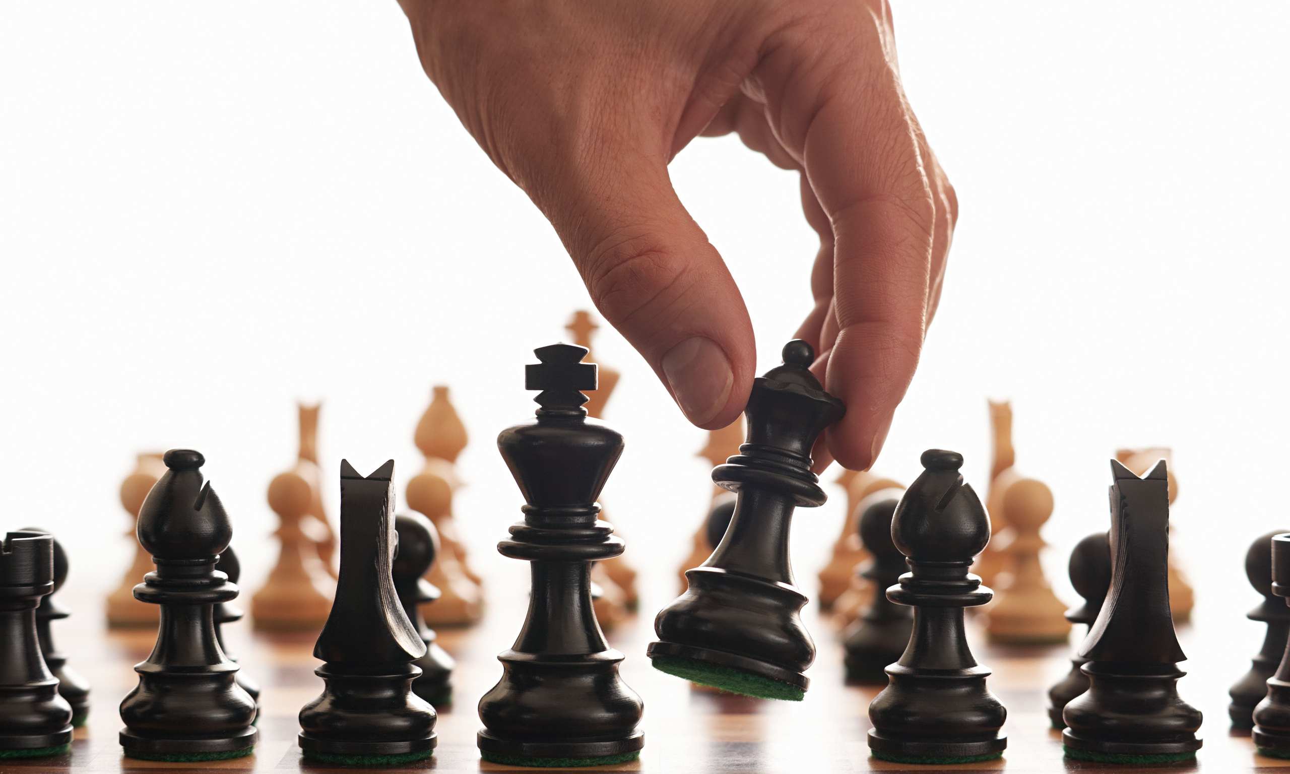 A hand moving a chess piece during a game